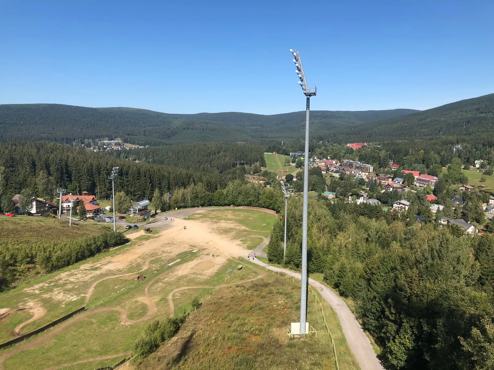Výběh shora, stožár osvětlení a Harrachov.