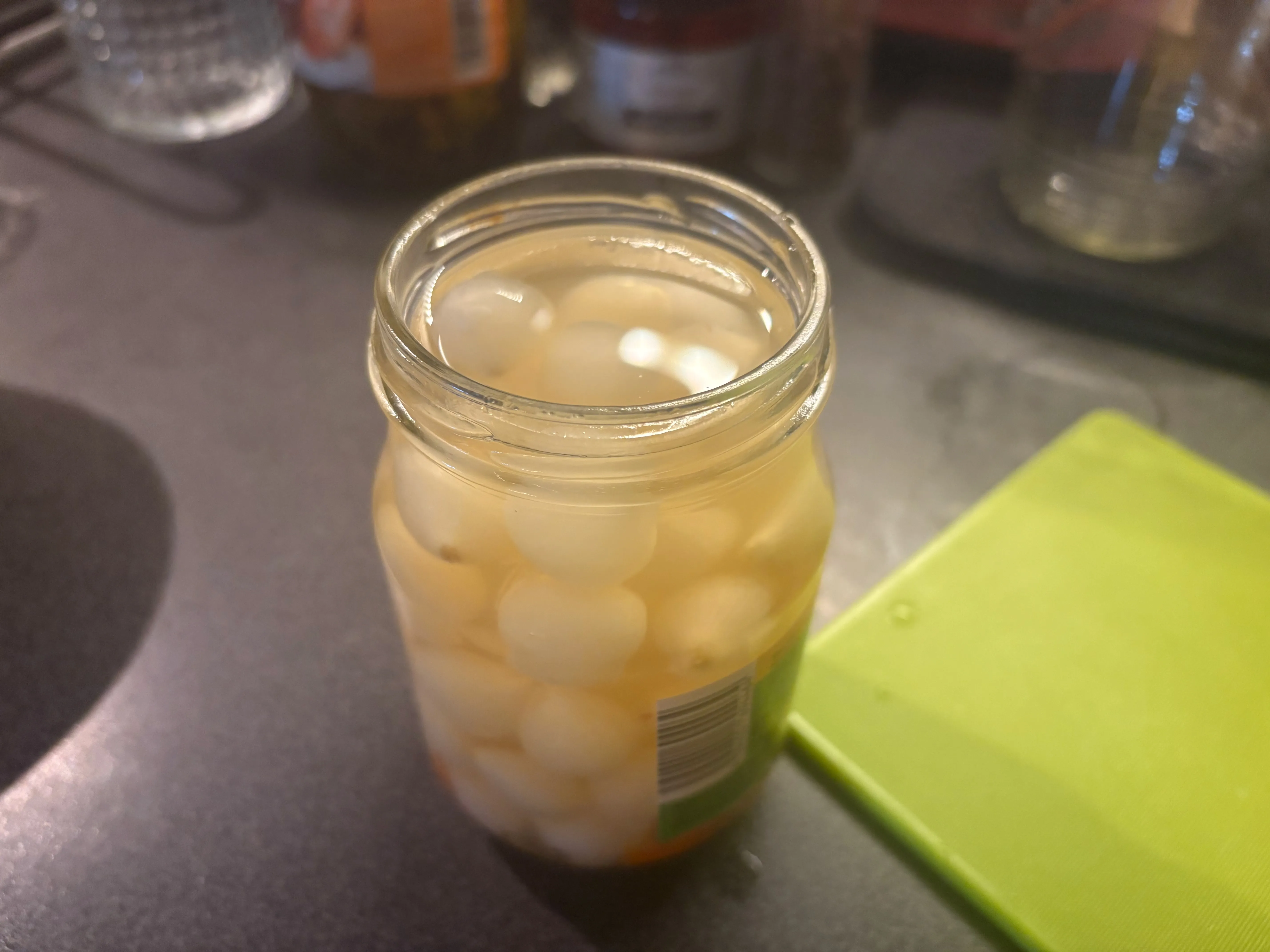 Sklenice s nakládanými perleťovými cibulkami v nálevu