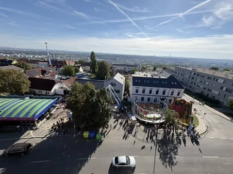 Pohled shora na centrální část pouti - kolotoč, ferris wheel a průjezd auta uprostřed