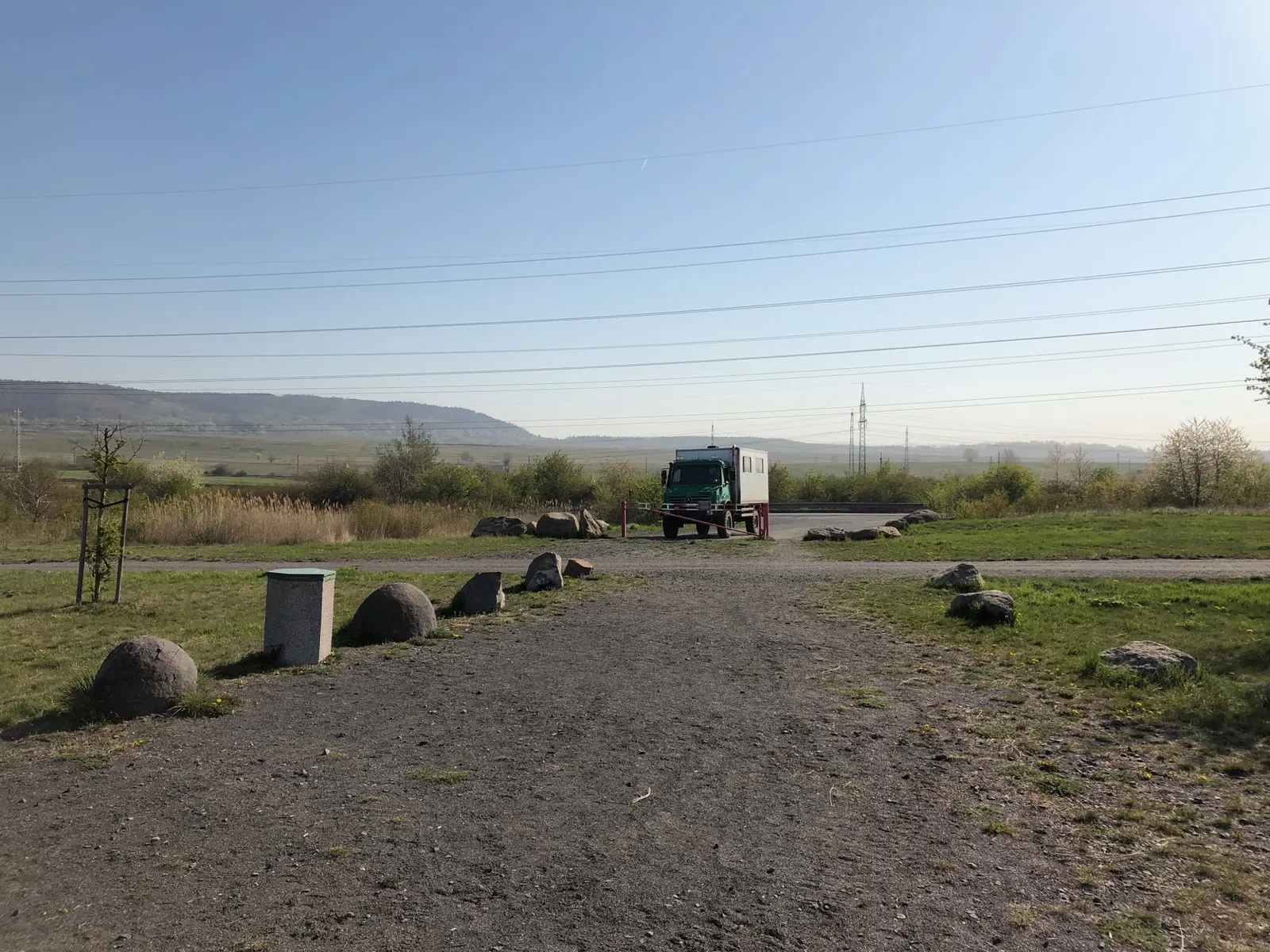 Mercedes Unimog s bílou pasažérskou kabinou u závory na vjezdu do dobývacího prostoru