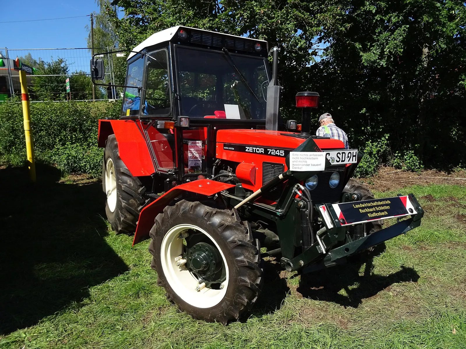 Červený Zetor 7245 Horal s kabinou, rozšířenými blatníky a předním tříbodovým závěsem na srazu v Německu